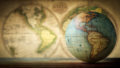 Old globe on vintage map background. Selective focus. Travel, stories and education background.