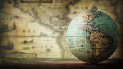 Old globe on vintage map background. Selective focus. Travel, stories and education background. - obrazy, fototapety, plakaty