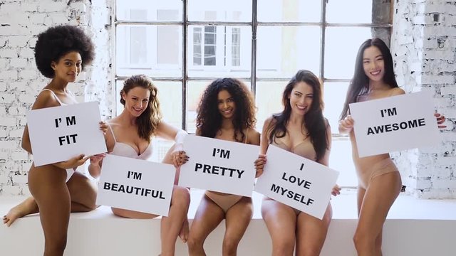 Group of multi ethnic women with different kind of beauty and body, posing and having fun in a studio