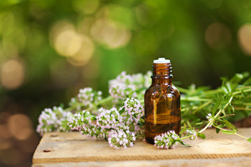 Little brown bottle with water or liquid on wooden board