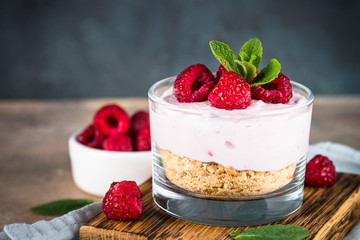 No baked cheesecake with raspberry in glass jar.