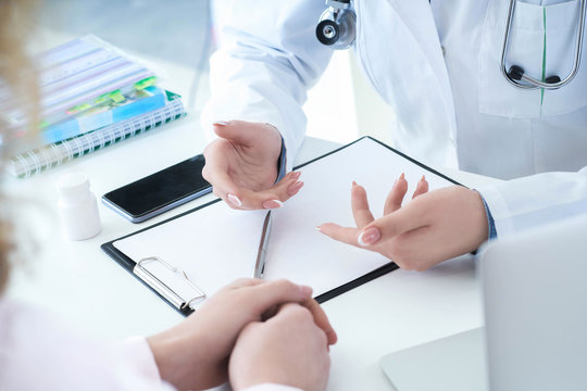 Patient Listening Intently To A Female Doctor Explaining Patient Symptoms Or Asking A Question As They Discuss Together In A Consultation.