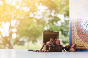Ramadan kareem with dates, rosary and holy quran on fresh green background