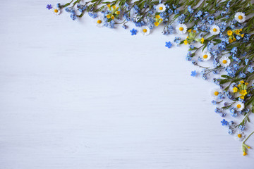 Spring flowers of forget-me-not, daisies and primroses on a wooden background