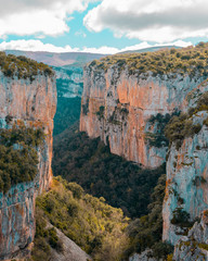 High cliffs with trees and blue sky.