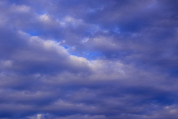 The sky in the clouds with the light of the sunset. The texture of the clouds, the background image.