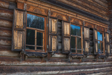 Fototapeta na wymiar facade of the old log house in the ancient village, traditional wooden architecture