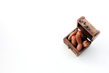 ramadan concept. dry dates in a wooden box isolated on white background