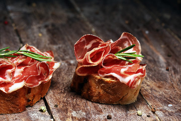 Italian sliced cured coppa with spices. Raw ham. Crudo or jamon with rosemary