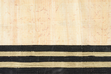 Authentic Egypt papyrus paper background with horizontal black and gold lines. Close up macro...