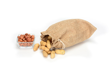 Peanuts. Jute burlap sack full of peanuts and glass bowl with peeled kernels, isolated on white background.