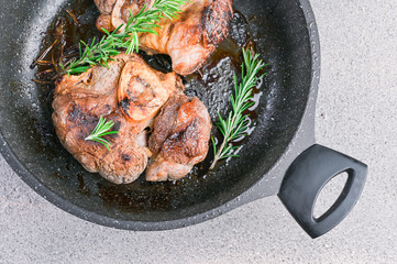 Large pieces of meat fried in a pan for lunch. Hearty and healthy lunch. Banner. Square format. Top view. Copy space.
