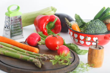 Mixed healthy vegetables on kitchen table and in the pot. Various colorful veggies, vegetarian meal ingredients
