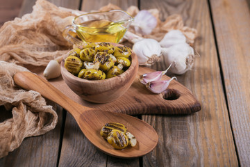 Grilled olives with garlic, olive oil and spices on wooden background