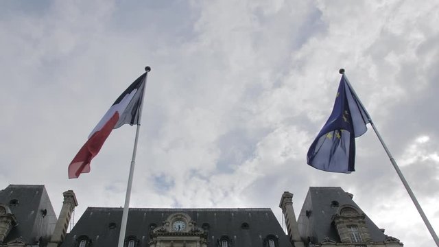 European Union flag and France flag waving in the wind against the blue sky. The concept of patriotism. Slow Motion.