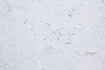 Texture of a wall painted with cracked white paint
