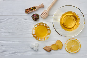 Cup of ginger tea with honey and lemon on wooden table. Flat lay composition with cup of hot tea.