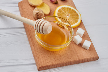 Honey with ginger and lemon on the cutting board. Best natural cold and flu recipe.