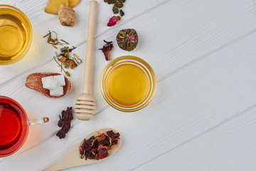 Tea, honey, ginger and copy space. Flat lay of delicious tea composition on white wooden background. Hot winter beverage.