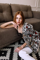 Obraz premium Beautiful sweet girl professionally posing on camera. Golden stylish model with short red hair, plump lips, casual clothing, costume, outfit, bra. Model test, clothing advertising