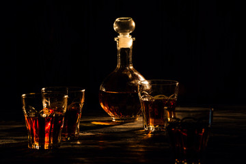 cognac in glasses and decanter, an exquisite alcoholic drink for men, shot in a dark light key