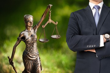 Lawyer standing with crossed arms, Scales of Justice on the background