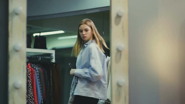 Attractive female customer is choosing skirt in fitting room