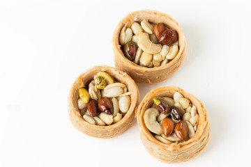 Traditional arabic dessert Kunafa with honey and nuts, on a white background,  selective focus
