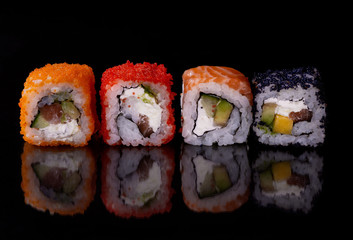 Japanese food,close-up  fresh sushi set of  four diferent types on black background with reflection