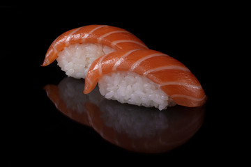 Close-up japanese food  sushi  with fresh salmon and rice on black background with reflection
