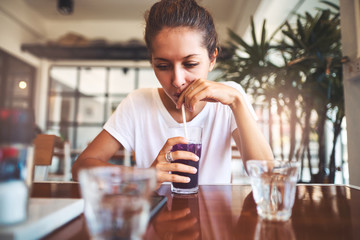 Portrait of beautiful girl using her mobile phone in cafe.