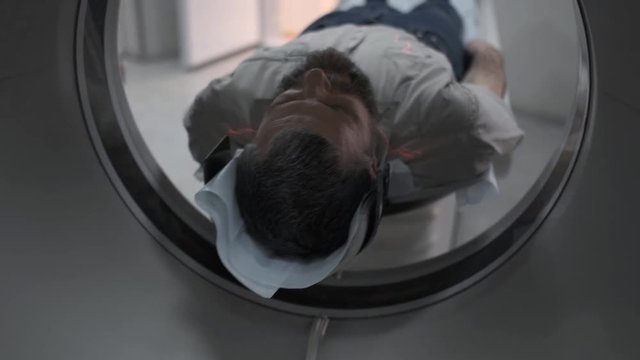 Male Patient On The Ct Or Mri Scanner Machine During X-Ray Process, Crane Shot. 4k