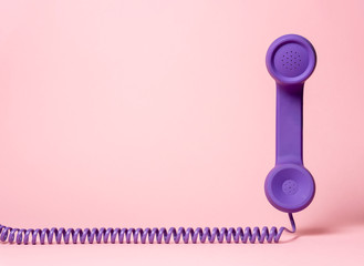 Retro telephone handset on a pink background