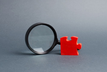 Red puzzle and magnifying glass. The concept of finding the missing detail or element in the general plan or strategy. Business planning, information gathering. Controlling stake. Key employee.