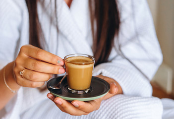 Close-up image of a woman holding a coffee mug.