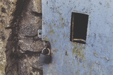Old steel door with a window closed on the lock. The concept of detention, prison, freedom.