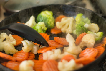 Cooking fried vegetables in a pan. The concept of healthy vegetarian food, diet.