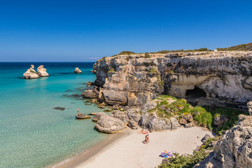 The bay of Torre dell'Orso, with its high cliffs, in Salento, Puglia, Italy. Turquoise sea and blue...