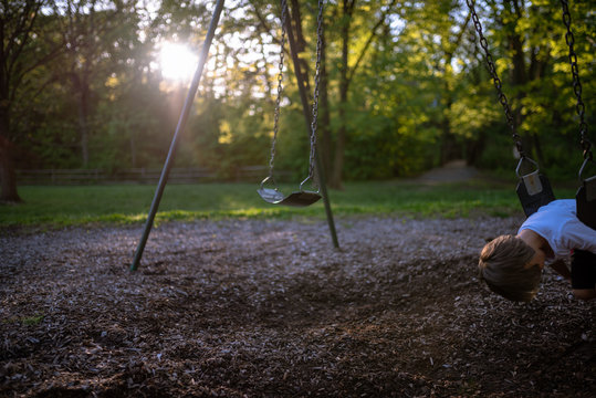 Child on a swing in the park - Powered by Adobe