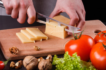 young woman slicing cheese in a gray apron