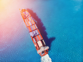 Logistics transportation of International container cargo ship in blue ocean. Top view aerial....
