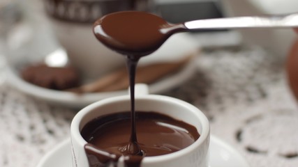 hand mixing chocolate in a hot milk, preparing hot chocolate or cacao, bautiful soft focus shot