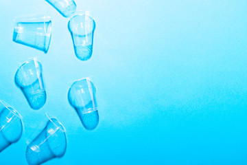 Plastic cups on blue background.