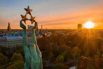 Beautiful sunset view over Riga by the statue of liberty - Milda in Latvia. The monument of freedom. People gathering around the monument for the concert. © Aerial Film Studio