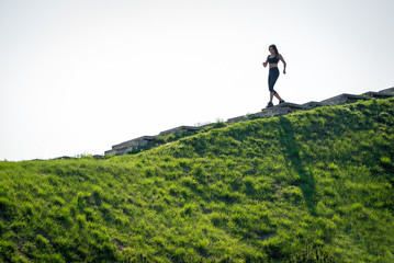 Slender beautiful girl with dark hair runs down the stairs, a symbol of healthy lifestyles, a strong leader and healthy competition
