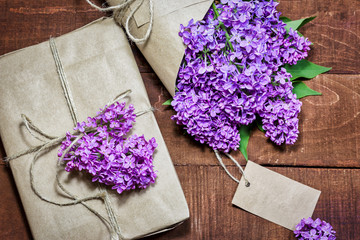 Obraz na płótnie Canvas Gift and bouquet of lilacs on a wooden table
