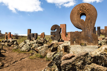 monument statue alphabet letters made of stone standing on  rocks on the nature of abstraction