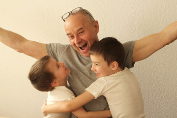 Two boys in white clothes and a man on a light background close-up. Concept family