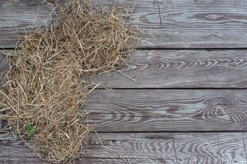 Hay on the brown aged wooden board background