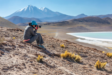 Landscape woman photographer taking photos in an amazing wilderness environment at Atacama Desert Andes mountains lagoons. A woman cut out silhouette over the awe Tuyajto Lagoon scenery at Altiplano © abriendomundo